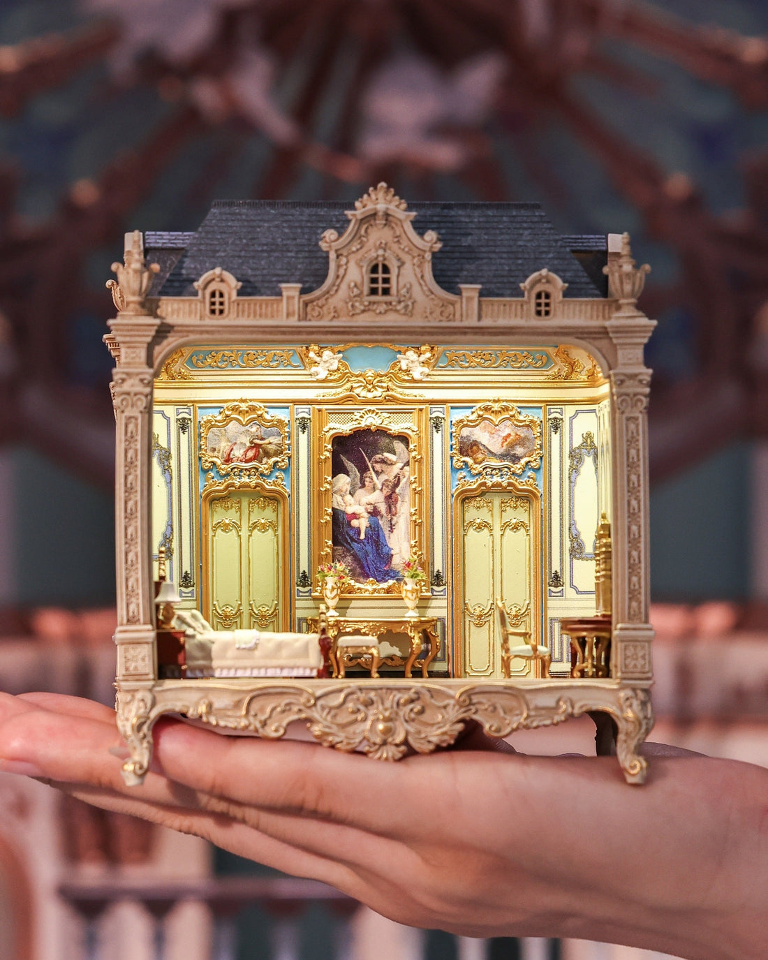 Brighton Manor miniature held in one hand, with its warm-lit classical interior facing forward