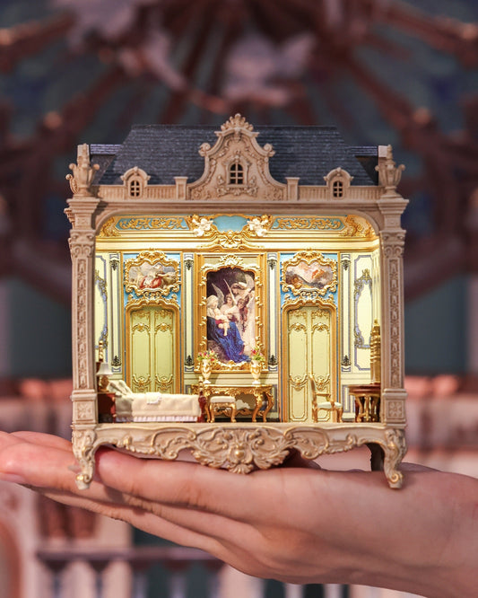 Brighton Manor miniature held in one hand, with its warm-lit classical interior facing forward